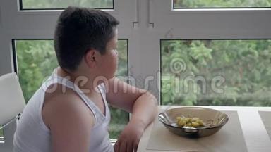 小胖小子坐在窗边吃着好吃的.. 儿童肥胖